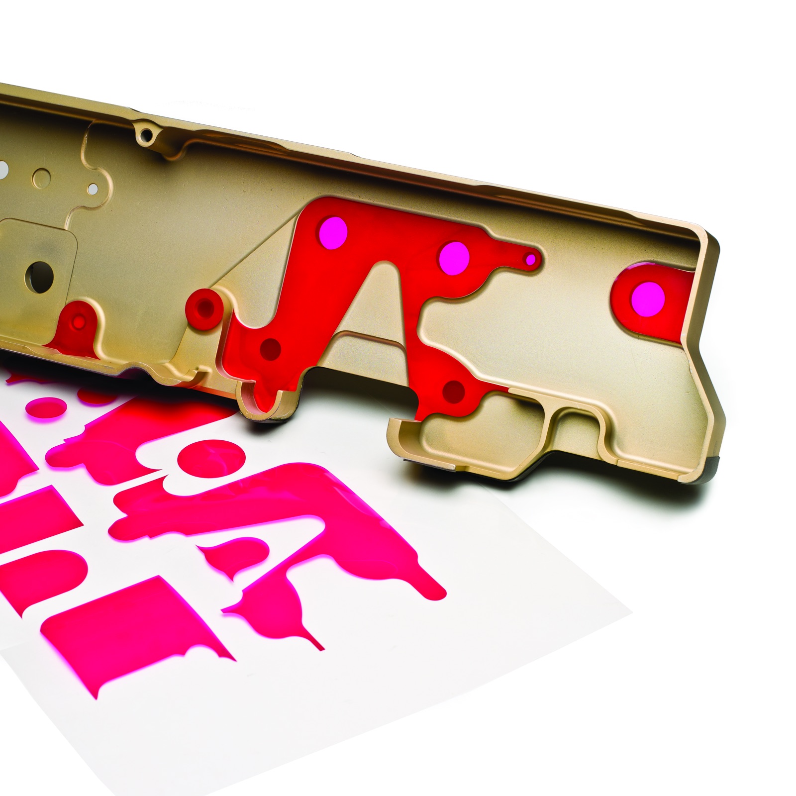 Red die-cut masks applied to a gold finished metal part